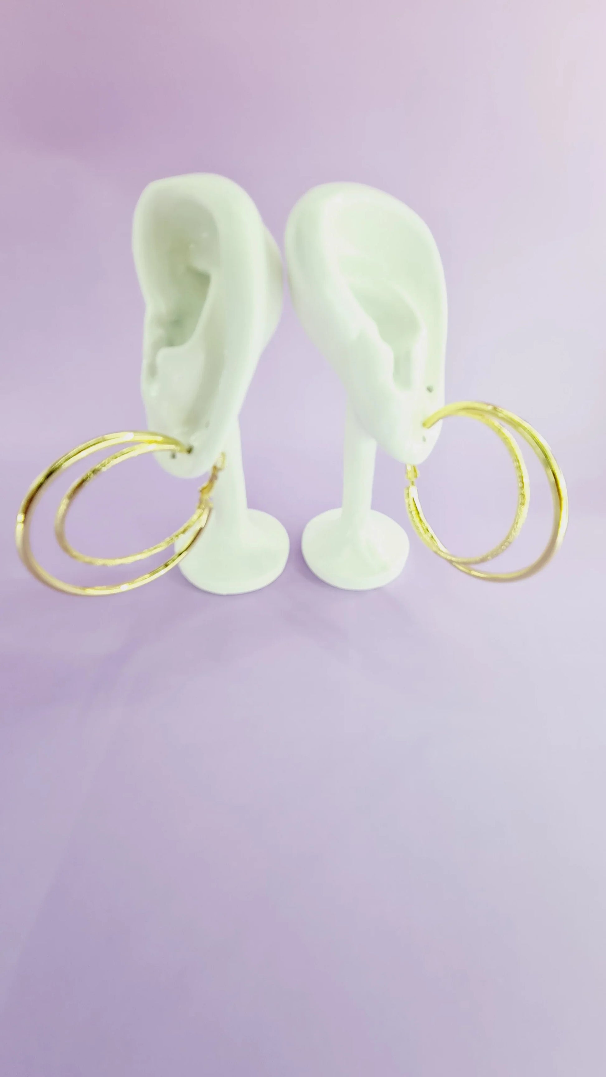 Créoles dorées pour femme sur présentoir oreilles, fond violet, 974 Réunion tendance