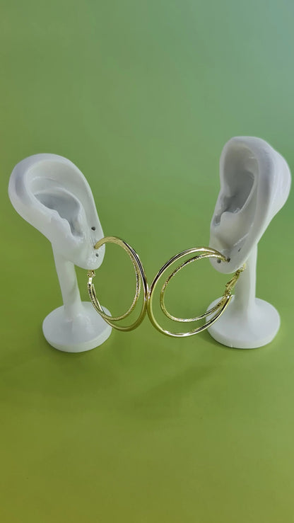Boucles d’oreilles créoles dorées sur présentoirs oreilles, fond vert, 974 reunion.