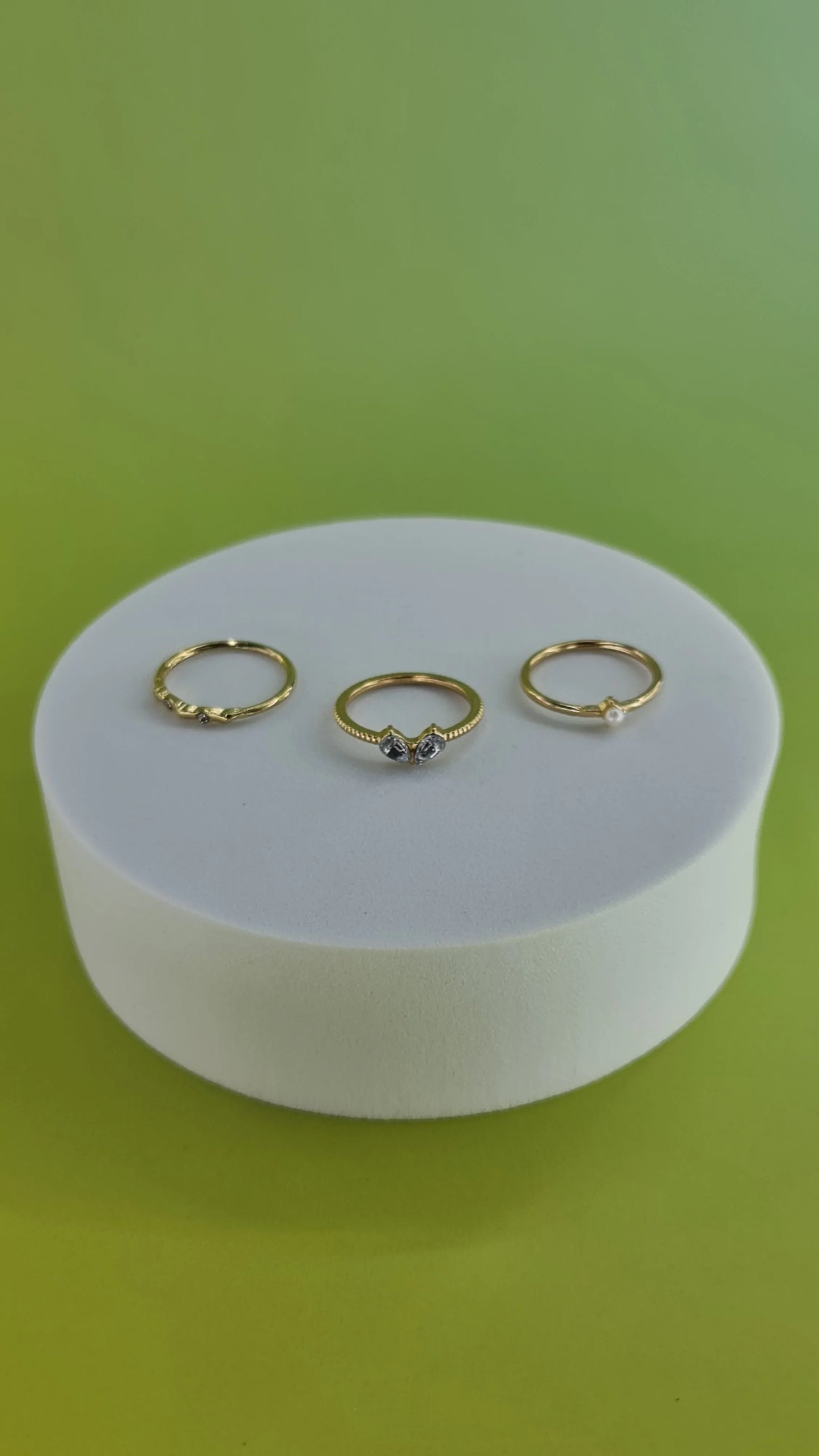 Trois bagues fines dorées sur support blanc, fond vert, bijoux femme 974 Réunion