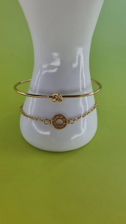 Duo de bracelets dorés femme, motif cercle et noeud, bijou tendance 974 Réunion, fond vert.