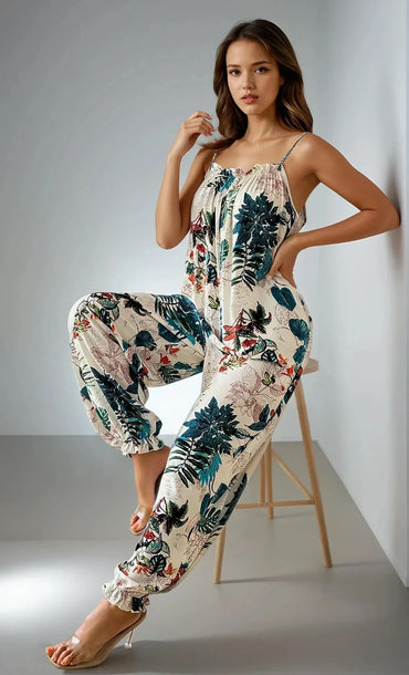 Femme en combinaison tropicale à motifs floraux, mode tendance 974 Réunion, pose élégante intérieure.