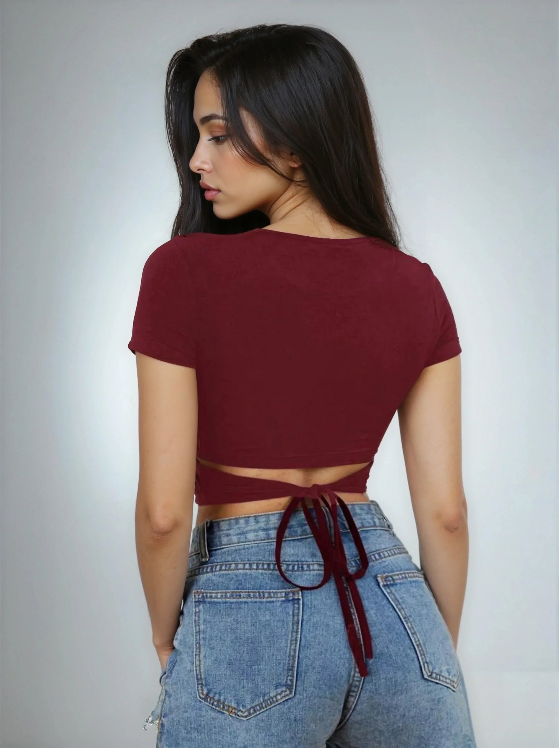 Jeune femme de dos portant un crop top bordeaux à nouer et un jean bleu, 974 Réunion.