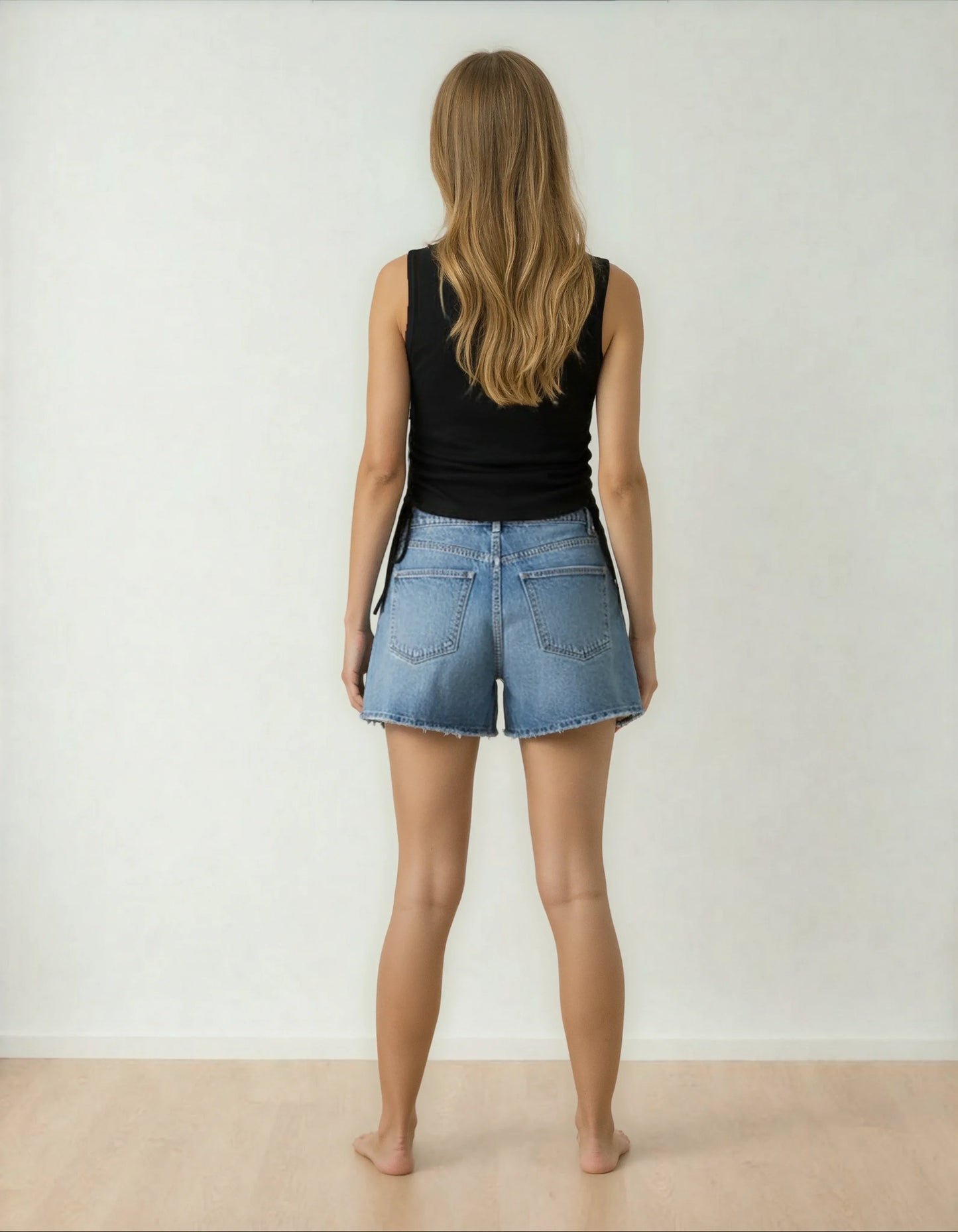 Femme de dos en short en jean et débardeur noir, style tendance 974 Réunion
