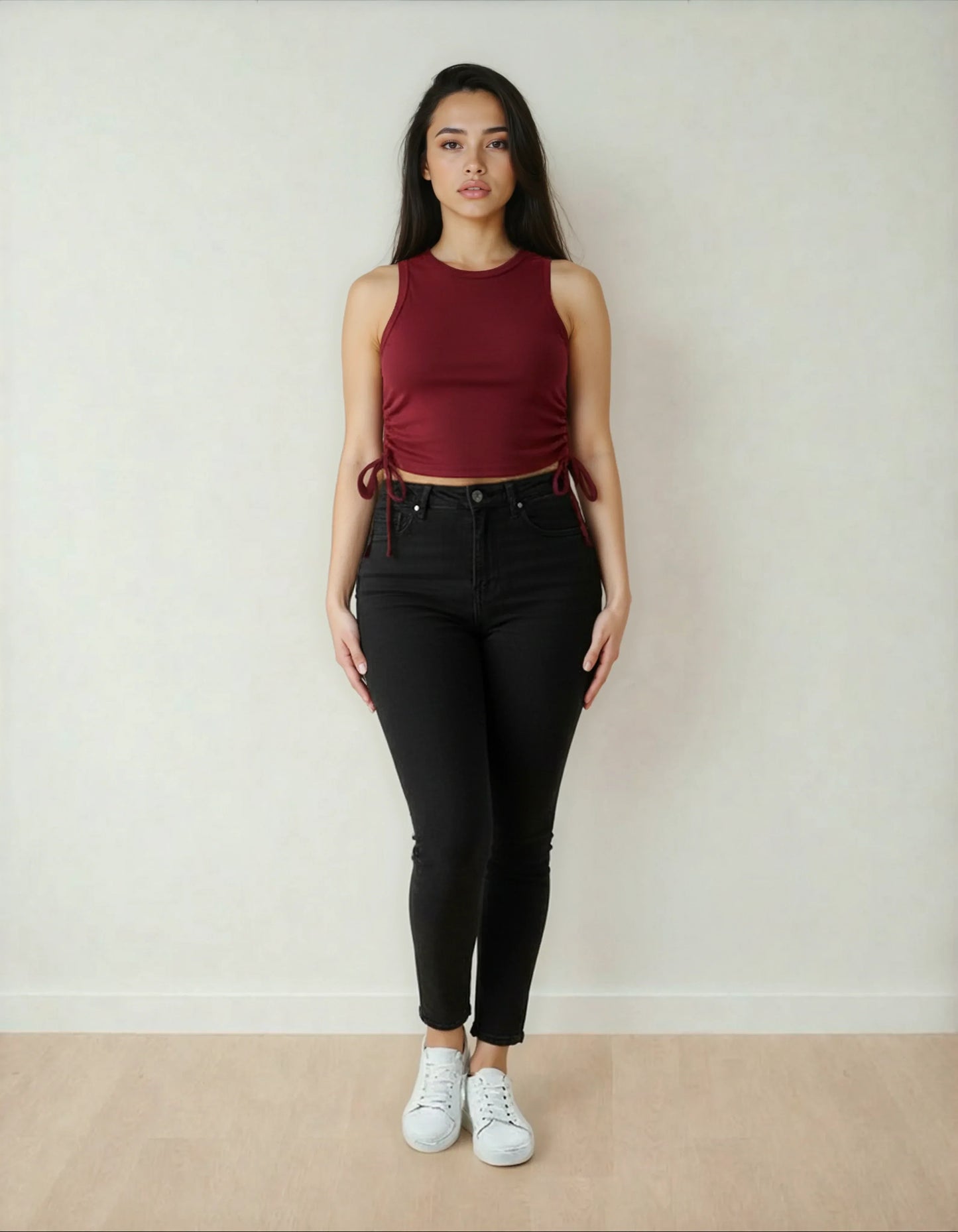 Femme debout, portant un crop top bordeaux et un pantalon noir, mode tendance 974 Réunion
