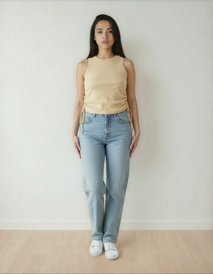 Femme portant un débardeur beige et un jean droit clair, mode tendance 974 Réunion.