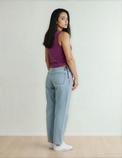 Femme en débardeur violet et jean clair tendance, intérieur minimaliste, 974 Réunion