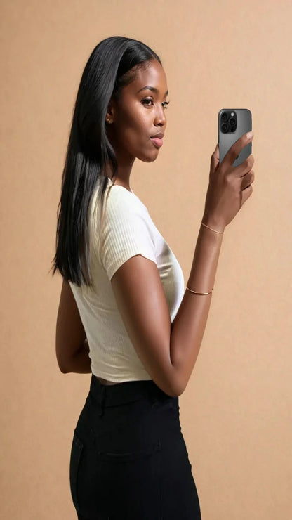 Femme portant un top court blanc et pantalon noir, selfie mode 974 Réunion, fond beige.